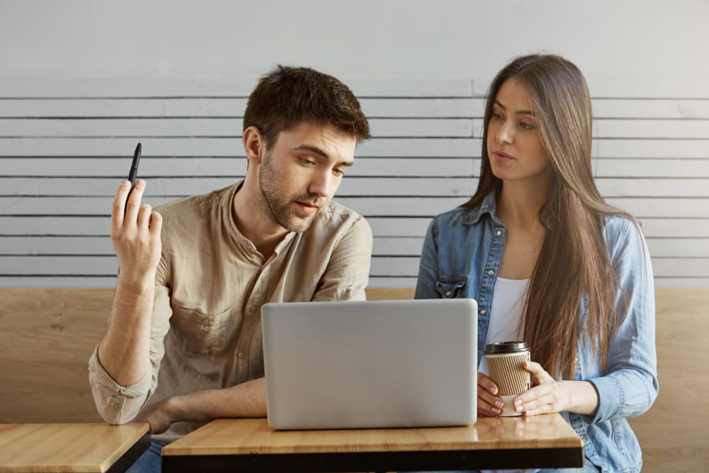 two people discussing over a laptop